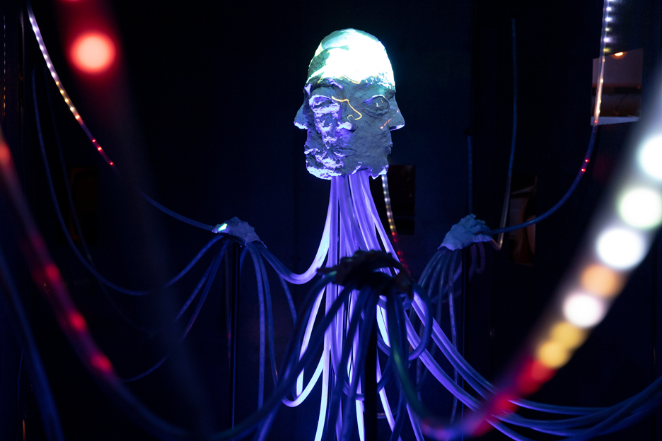 Sculpture of a head with light effects in the middle of the exhibitio